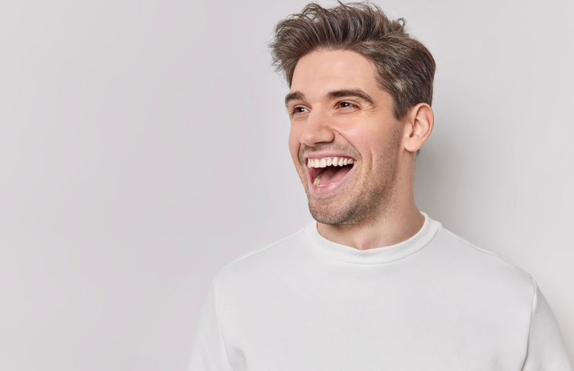 hombre joven castaño riendo feliz camiseta blanca fondo blanco