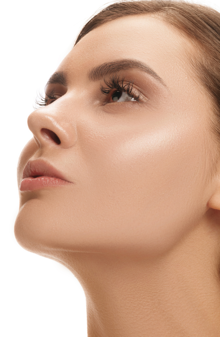 mujer mediana edad cutis perfecto mirando hacia arriba de perfil fondo blanco belleza