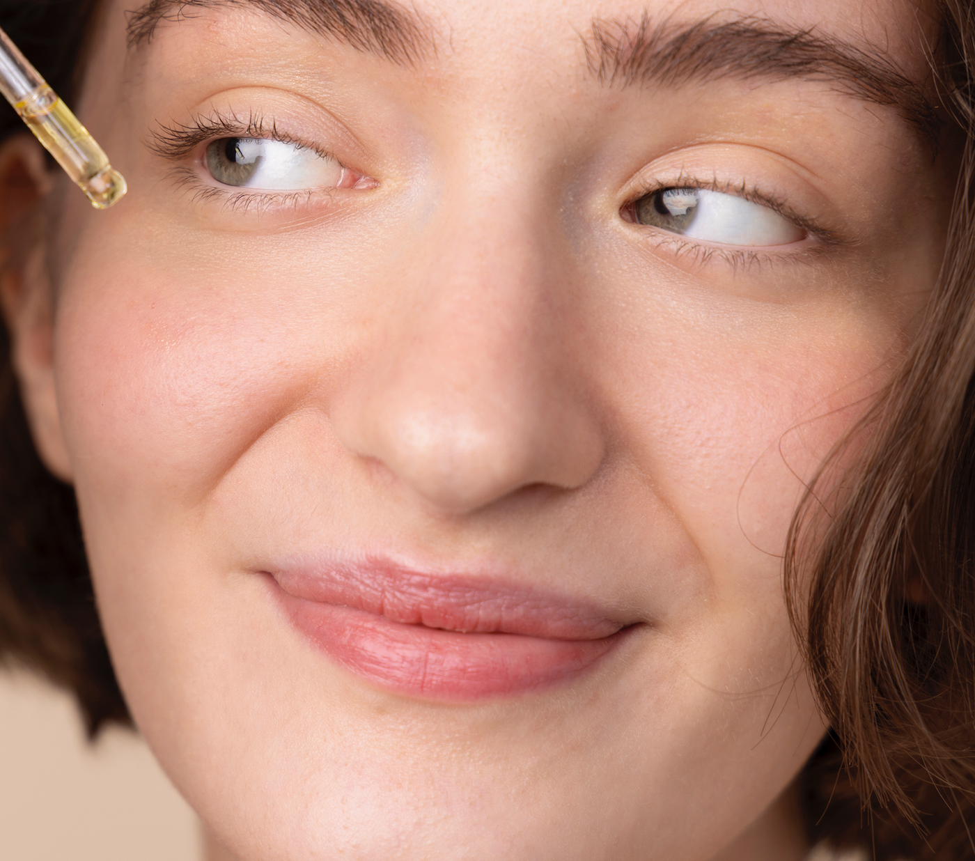 mujer echándose serum en la cara 
