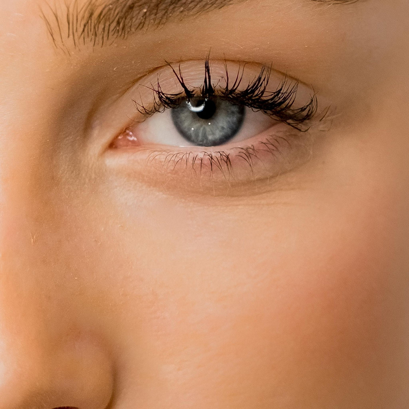 Mujer con contorno de ojos hidratado, sin ojeras ni arrugas, piel luminosa y saludable