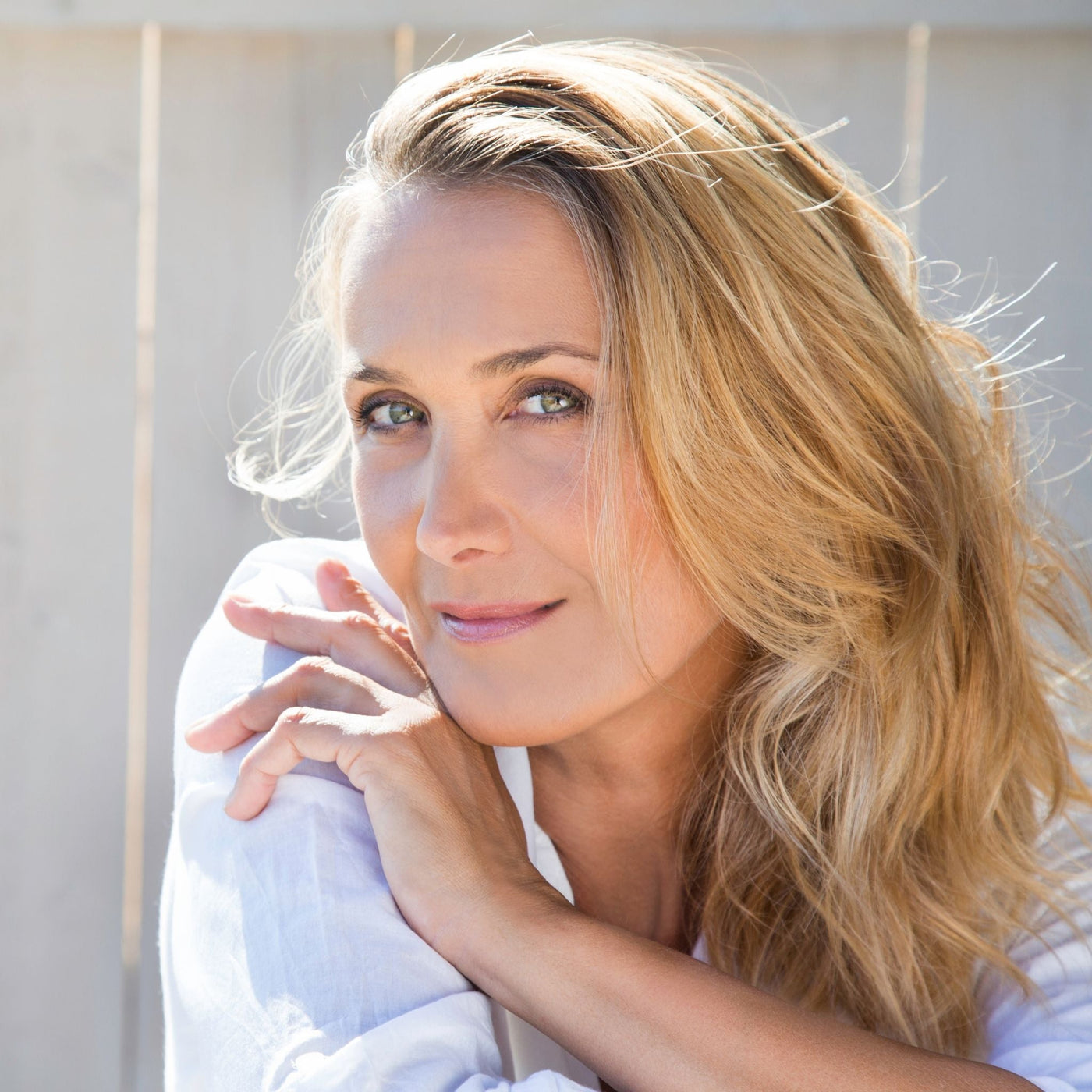 Mujer de 40 años con piel natural mostrando la zona de la barbilla y mandíbula, cuidando su piel con productos naturales.