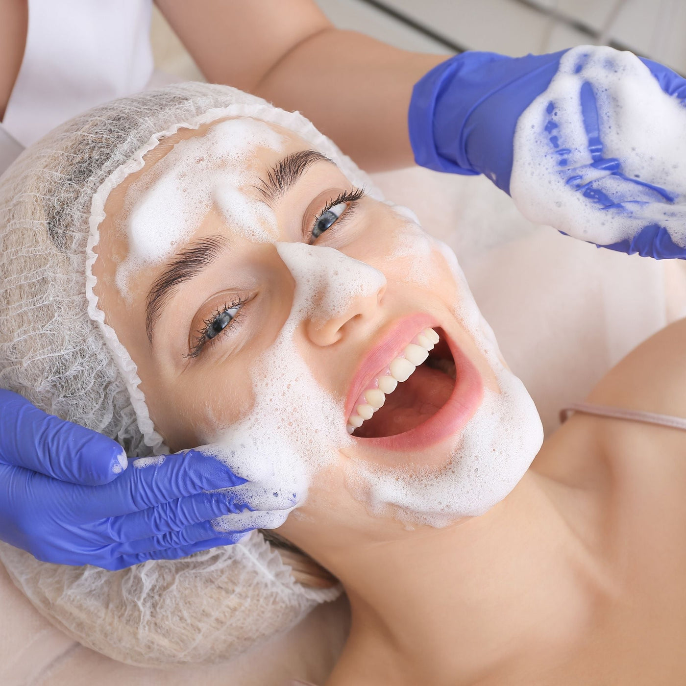 Mujer recibiendo limpieza facial suave que protege el microbioma cutáneo y mantiene la piel equilibrada