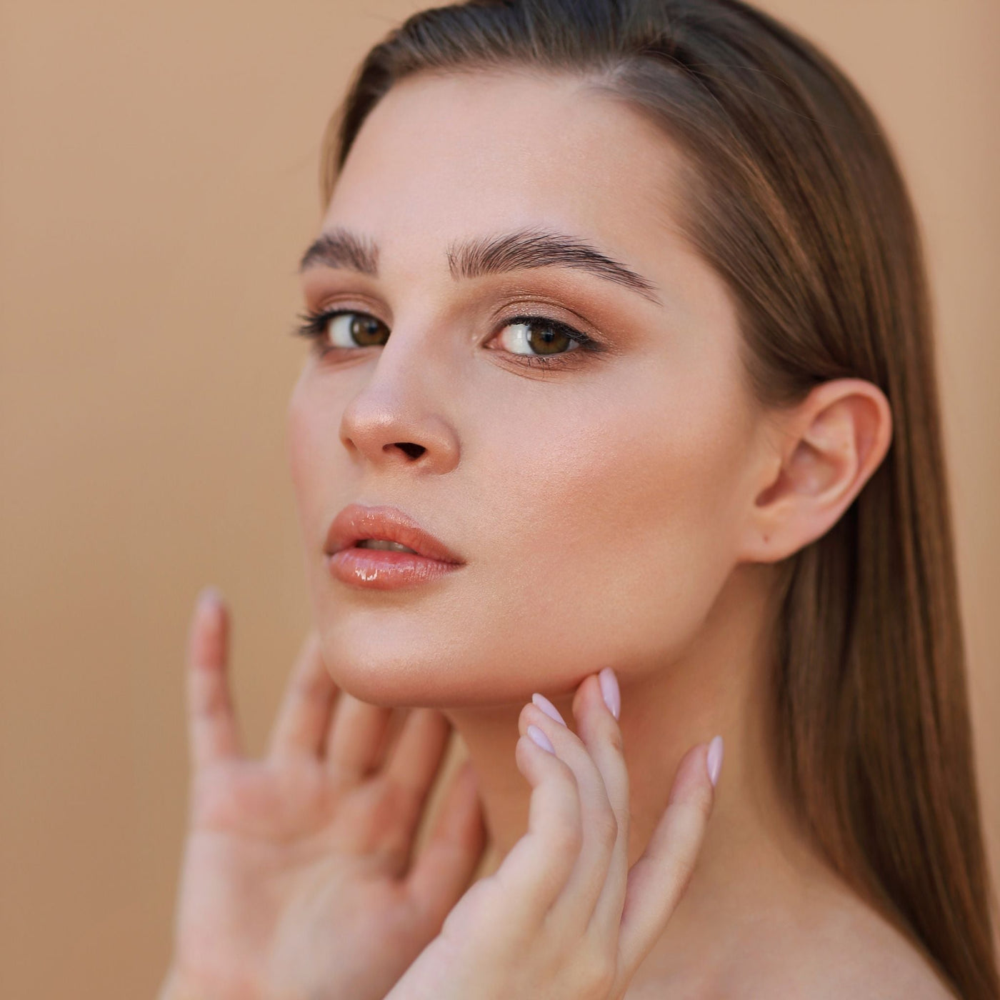 Mujer con piel sensible tocándose la cara, símbolo del cuidado natural para la rosácea en verano con OhMyKoko.