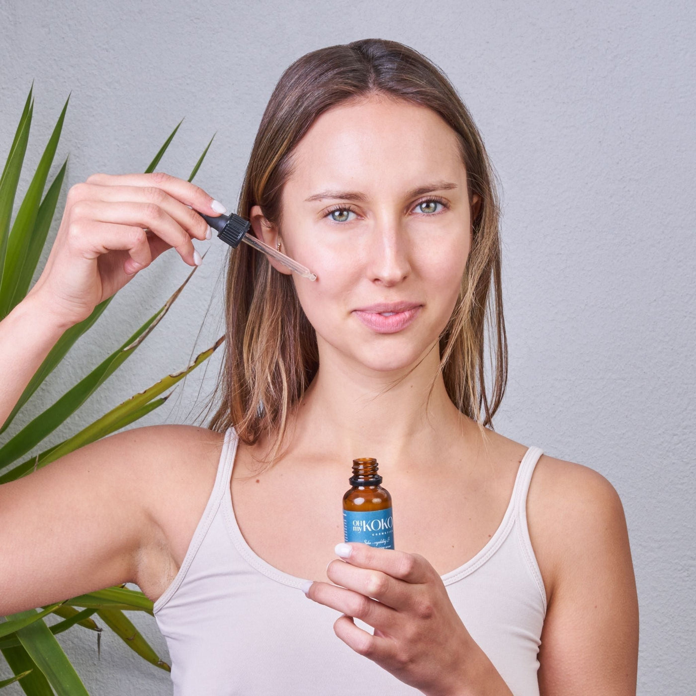 Mujer aplicándose sérum facial OhMyKoko para combinarlo con crema y mejorar resultados en su piel